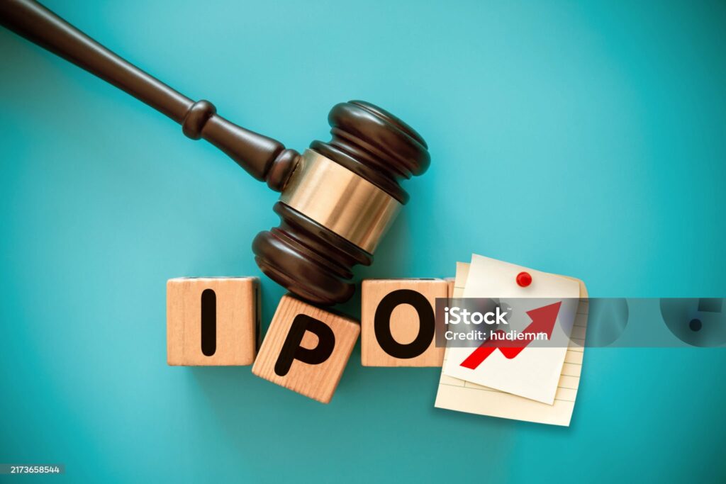 Gavel and toy block with IPO on blue background.